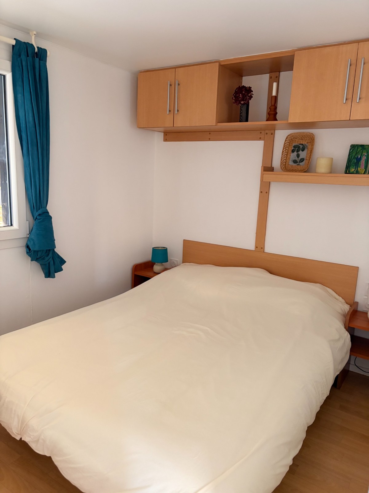 Chambre du démonstrateur avec lit double et rangements.