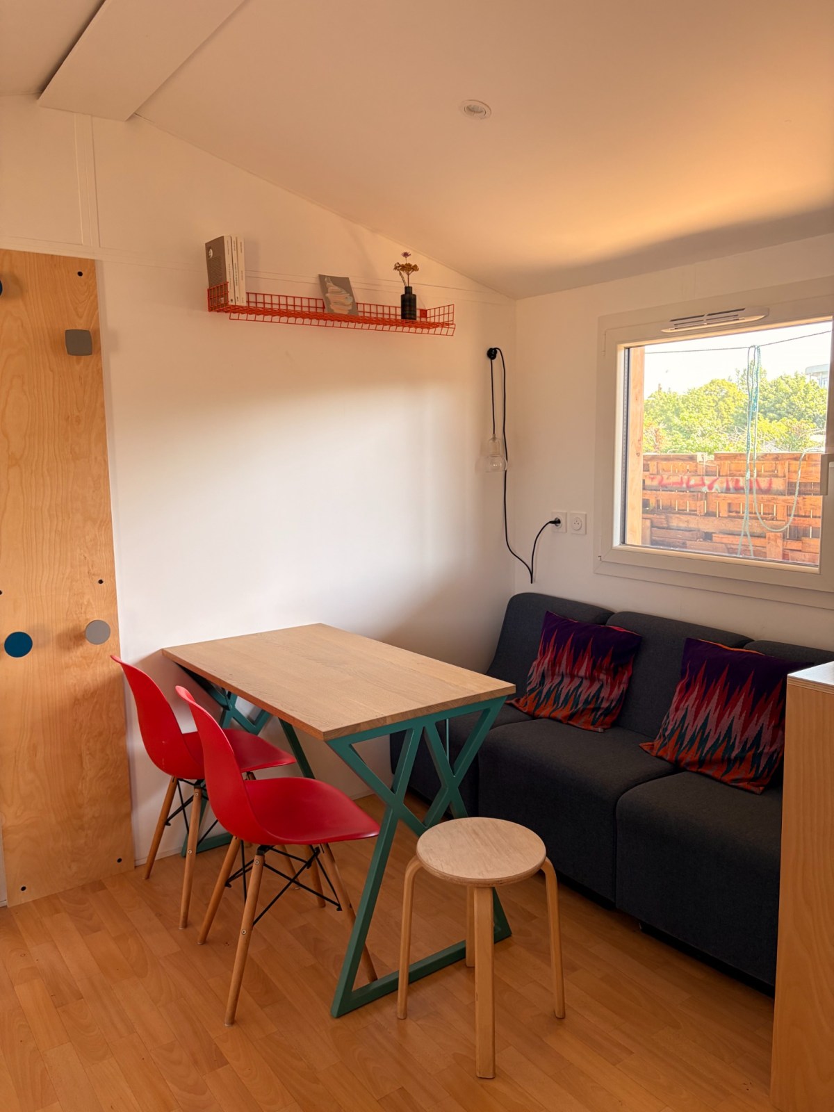 Séjour du démonstrateur avec table, banquette et fenêtre.